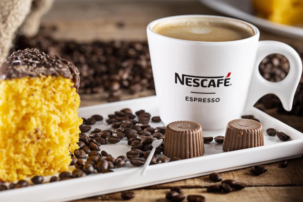 A cup of Nescafe coffee surrounded by images of healthy foods, workout equipment, and a measuring tape.
