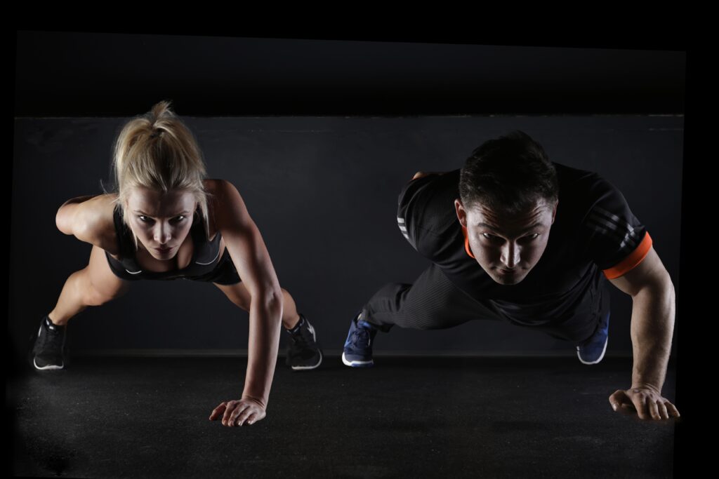 A couple performing Hot Pilates exercises together, demonstrating strength and flexibility in a fitness studio.

